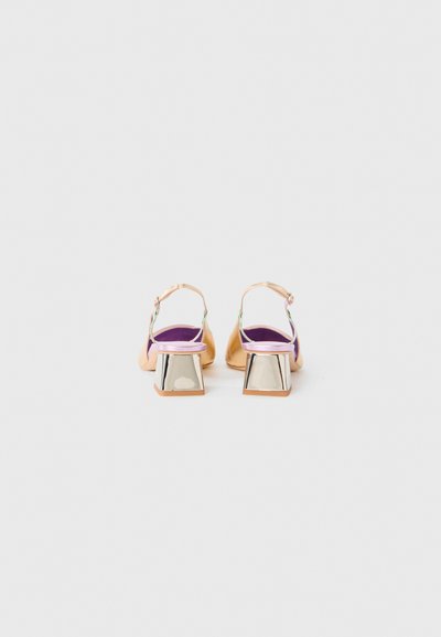 O pereche de încălțări cu toc slingback de culoare piersică, cu branțuri mov și tocuri bloc reflectorizante argintii, prezentate din spate pe un fundal alb.