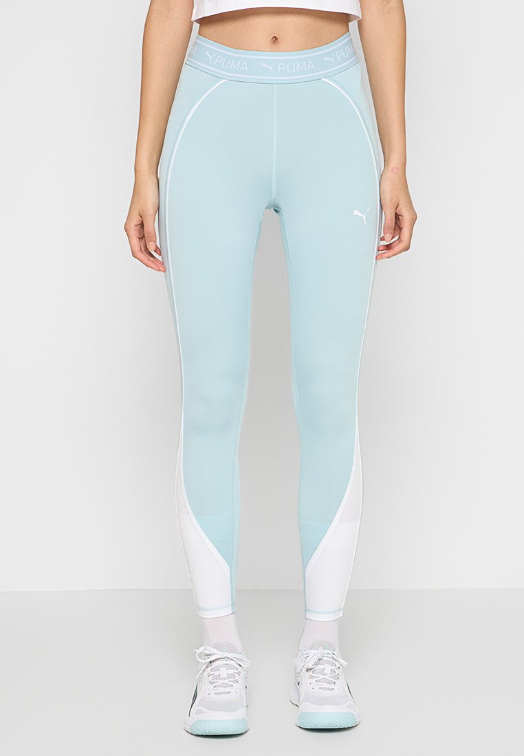 Leggings sportivi azzurro chiaro con vita alta, dotati di dettagli bianchi e una finitura liscia e elasticizzata. Logo Puma visibile.
