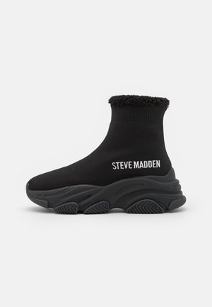 Black sock-style sneaker with thick textured sole, furry interior cuff, and "STEVE MADDEN" logo on the side.