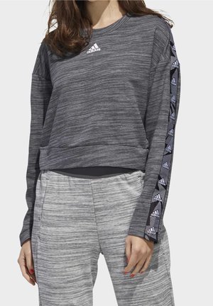 Sweatshirt gris à manches longues avec une finition texturée et un col rond. Il présente des bandes latérales à motifs contrastés et un logo adidas sur la poitrine.