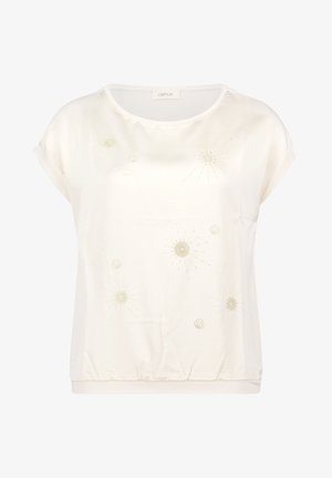 Blouse crème à manches courtes avec encolure ronde, ourlet élastique, et motifs délicats de broderie florale dorée et coquillages sur le devant.