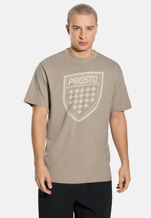 Beżowy bawełniany t-shirt z krótkimi rękawami, z dużym jasnym logo w kształcie tarczy i wzorem kratki na przodzie. Okrągły dekolt.