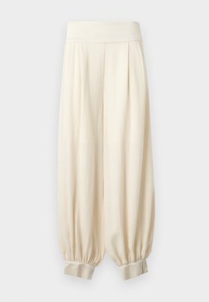 Φαρδιά εκρού παντελόνια με φαρδιά ελαστική μέση και μαζεμένα μανσέτες στους αστραγάλους, κατασκευασμένα από ελαφρύ ύφασμα.