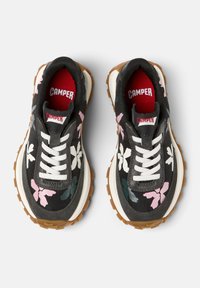 Black canvas sneakers with floral patterns in pink and green. Features white laces, padded collar, and thick rubber sole with traction.