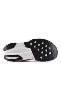 Suela de zapato atlético con un caucho texturizado negro y patrones triangulares, plantilla blanca y acentos rojos. Diseño duradero y flexible.