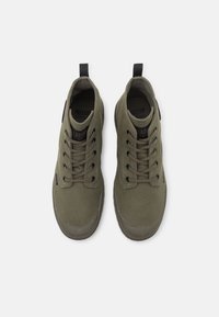 Olive green high-top canvas sneakers with a round toe, flat laces, and a rubber sole; features pull tabs and a textured finish.