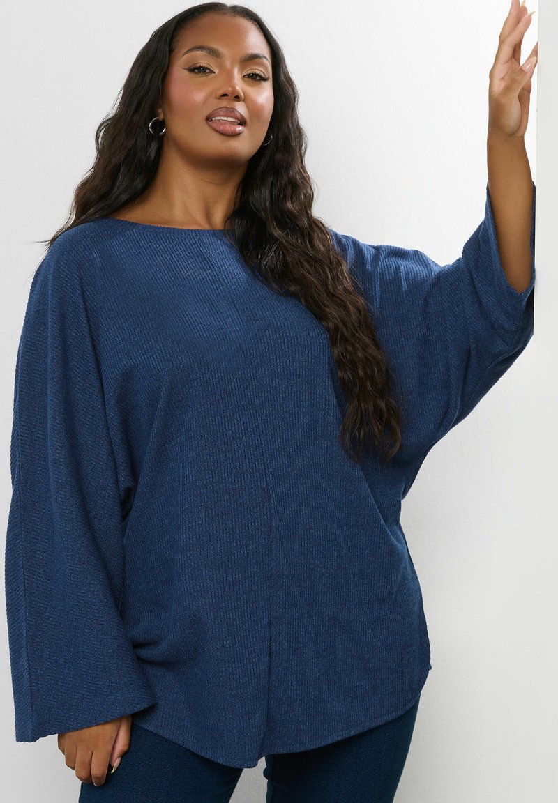 Lässig sitzender, strukturierter, tiefblauer Pullover mit weiten Ärmeln und Rundhalsausschnitt. Weiches Material und ein leicht geschwungener Saum.