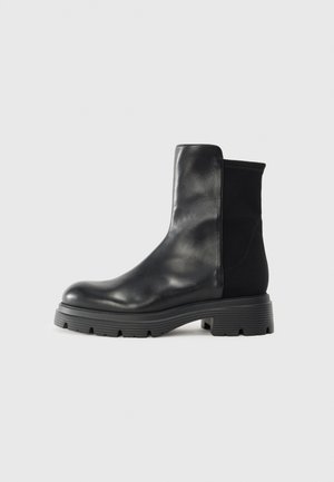 Stivaletti neri in pelle liscia con pannelli laterali elastici, suola in gomma spessa e un design elegante e moderno.