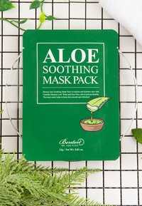 Il packaging verde per il Benton Aloe Soothing Mask Pack presenta un testo bianco e un'illustrazione di una foglia di aloe in un vaso. La maschera pesa 23g.
