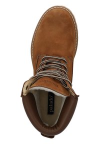 Botín de ante marrón con forro de piel sintética blanca, cordones marrones redondeados y suela color crema. Presenta un diseño cosido y un cuello acolchado.