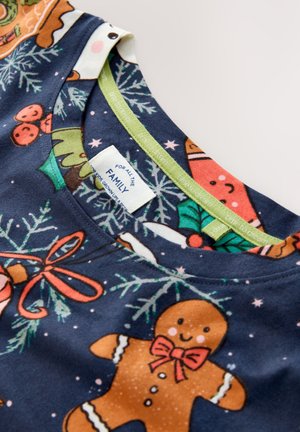 Maglietta di cotone blu navy con stampe a tema natalizio, tra cui omini di pan di zenzero e alberi di Natale, con collo rotondo e bordatura verde.