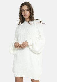 Biała dzianinowa sukienka swetrowa wykonana z miękkiego materiału, z prążkowaną fakturą, oversize'owymi balonowymi rękawami i okrągłym dekoltem.