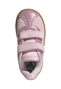 Roza atletska tenisica s teksturiranim gornjim dijelom od brušene kože, naglascima od sjaja i s dva čičak remena. Gumeni potplat i Adidas oznaka na ulošku.