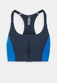 Marineblå sports-bh med blå sidepaneler, glidelås foran og brede skulderstropper. Laget av elastisk stoff med en jevn tekstur.