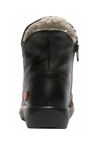 Bota de cuero negra con cremallera trasera, que cuenta con un suave forro de felpa blanca en la parte superior y una suela negra plana y texturizada.
