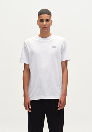 Tricou alb din bumbac, cu mâneci scurte și decolteu rotund. Are un mic logo imprimat în negru în zona superioară stângă a pieptului.