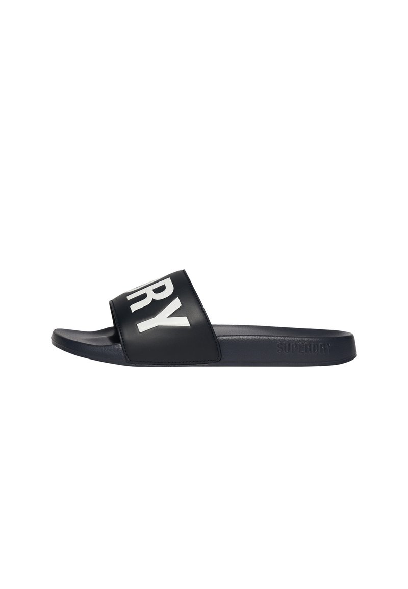 Sort slidesandal med bred øverste rem, der viser en del af den hvide "RY" tekst og et præget "Superdry" logo på siden af sålen.