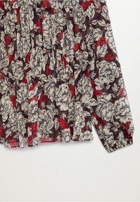 Blusa floreale con maniche lunghe, caratterizzata da un motivo multicolore di fiori bianchi e foglie rosse su uno sfondo scuro. Tessuto testurizzato.