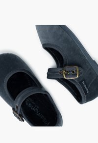 Zapatos de ante gris oscuro con punta redonda, que cuentan con una correa ajustable con hebilla y una textura suave y lisa.