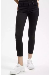 Czarne dżinsy skinny z średnim stanem, pięcioma kieszeniami i subtelnymi detalami haftu. W zestawieniu z białymi sneakersami sportowymi.