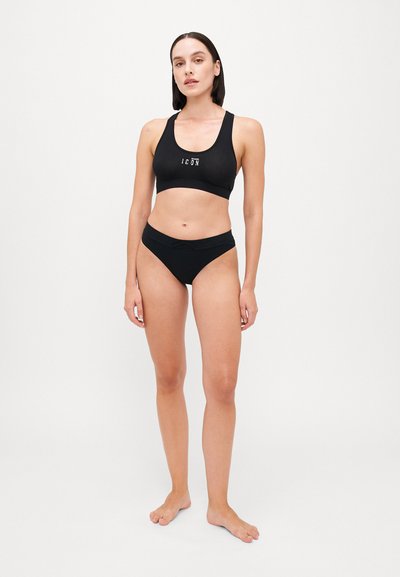 Black sports bra with a rounded neckline and logo, paired with black high-waisted bikini briefs. Smooth, stretchy fabric, minimal seams.