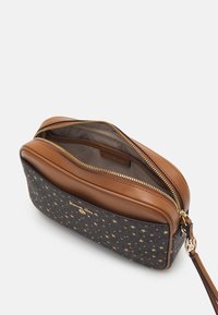 Pochette in pelle marrone e tela blu navy con un motivo a stelle dorate, dotata di doppia cerniera e di un logo decorativo vicino alla base. L'interno è beige.