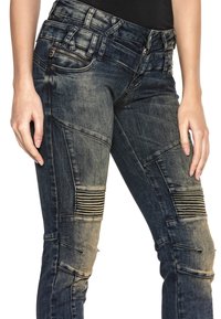 Blaue Jeans aus Denim mit einem verblassten Look, ausgestattet mit strukturierten Einsätzen und gerippten Akzenten an den Oberschenkeln. Funktionale Seitentaschen und metallene Reißverschlüsse.