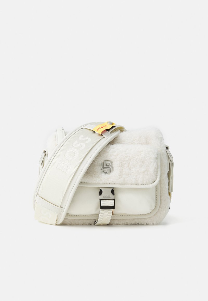 Hvit skulderveske med fluffy tekstur, metallhardware og justerbar stropp med "BOSS"-logo. Rektangulær form med klaffelukking.