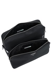Dopp kit in pelle nera con due scomparti, texture liscia, cerniere argentate e etichette interne di brand. Design compatto e rettangolare.