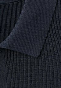 Tessuto lavorato a maglia blu navy con trama a coste e colletto piegato. Il materiale è morbido ed elastico, evidenziando un motivo uniforme e costante.