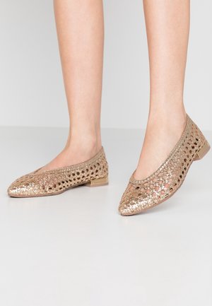 Beżowe, plecione baleriny z otwartym wzorem siateczki, spiczastym noskiem i niskim przezroczystym obcasem. Charakteryzują się błyszczącym wykończeniem dla dodatkowego efektu.