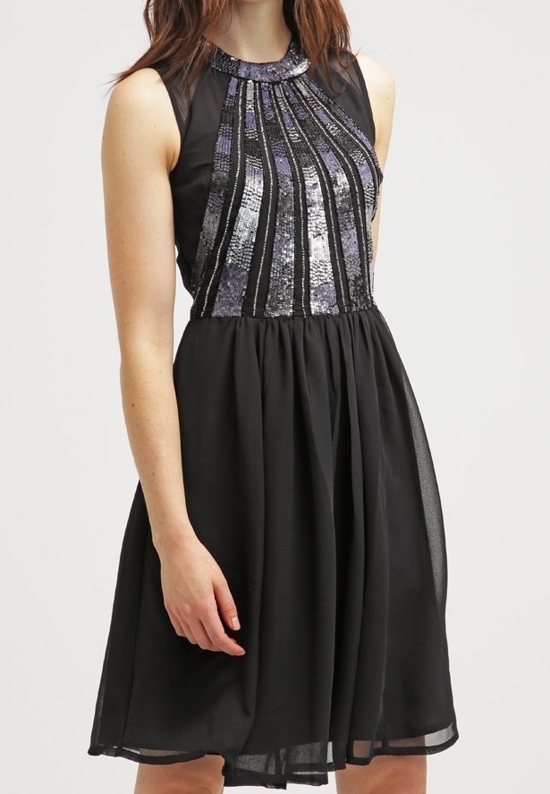 Mustapuku, jossa on tiukka yläosa, joka sisältää hopeanvärisiä kimallekuvioita, liehuva hameosa ja hihaton malli. Silkkinen kankaan tekstuuri.