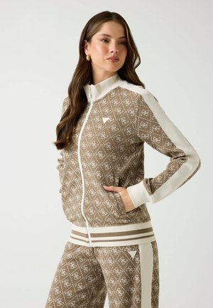 Giacca marrone con zip e dettagli bianchi, caratterizzata da un motivo a logo, polsini a costine e pantaloni abbinati con cintura striata. Tessuto dalla texture liscia.