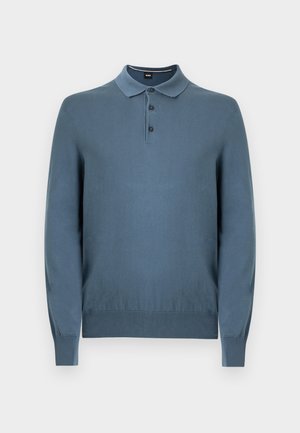 Sinine pika varrukaga polo kampsun, valmistatud kootud kangast, millel on klassikaline krae, kolme nupuga plastron ning soonilised varrukaportsud ja ääred.