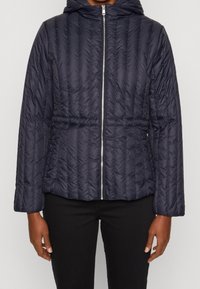 Marineblauer Pufferjacke mit Kapuze, vertikaler Quiltstruktur, Reißverschluss vorne und elastischem Bund, mit langen Ärmeln und seitlichen Taschen.