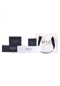 Collezione di scatole regalo in bianco e nero con il brand "MYC PARIS". Le scatole variano in dimensione, presentano superfici lisce e un design minimalista.