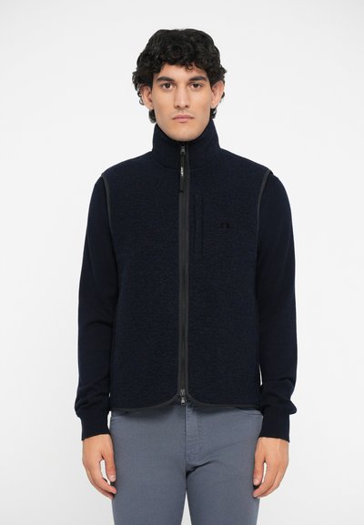 Chaleco de forro polar con cremallera en azul marino oscuro y mangas largas. Presenta un tejido texturizado, cuello alto y paneles laterales en contraste.