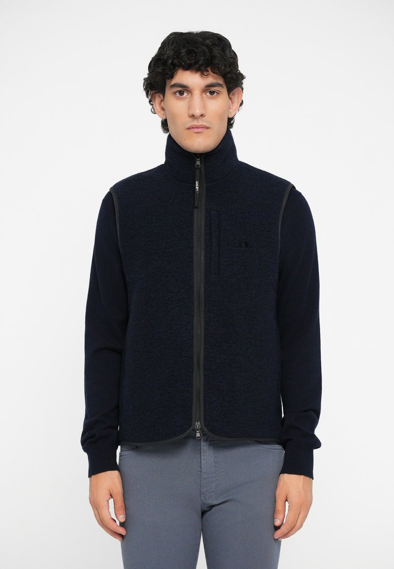 Reißverschluss-Fleece-Weste in Dunkeln Navy mit langen Ärmeln. Sie verfügt über einen strukturierten Stoff, einen Stehkragen und kontrastierende Seitenpaneele.
