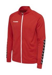 Rote zip-up Jacke aus strukturiertem Stoff, mit einem weißen Reißverschluss und schwarzen Chevron-Muster-Akzenten an den Ärmeln. Mit Markenlogo.