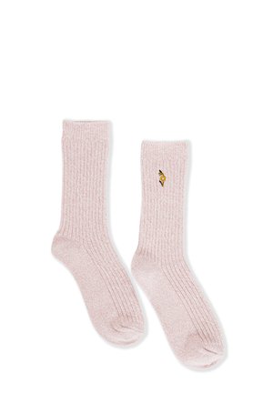 Hellrosa gerippte Stricksocken mit einer kleinen aufgestickten gelben Blume an der Außenseite eines Socken, flach auf einem weißen Hintergrund ausgelegt.
