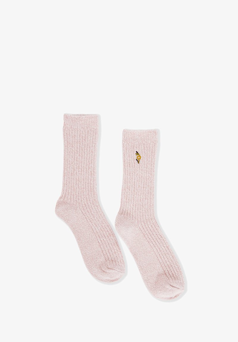 Calzettoni a coste rosa chiaro con un piccolo fiore giallo ricamato sul lato esterno di una calza, stesi su uno sfondo bianco.