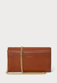 Brūns ādas maks ar zelta ķēdes siksniņu, ar gludu tekstūru un izspiestu logo priekšpusē. Kompakts taisnstūra dizains.