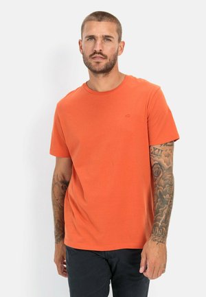 Oranje T-shirt met korte mouwen van katoen en een ronde hals. Bevat subtiele geborduurde logo's. De achtergrond is effen wit, waardoor het shirt opvalt.