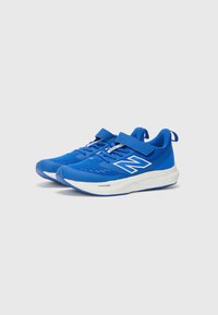 Baskets de sport bleues avec tige en mesh, languette rembourrée et sangle Velcro. Semelle intermédiaire blanche avec des accents texturés et le logo sur le côté.
