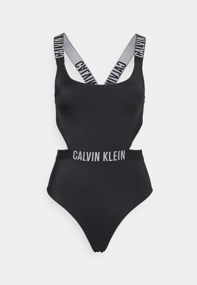 Svart badedrakt med kryssede stropper som har "CALVIN"-tekst, en bred midjebånd som viser "KLEIN," og en glatt, strømlinjeformet tekstur.