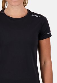 Maglietta sportiva nera a maniche corte con scollo rotondo, caratterizzata da sottili righe, dettagli riflettenti grigi sulle spalle e un logo sul petto.