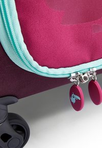 Paarse stoffen koffer met turkooise rits, zilverkleurige hardware en ronde trekknoppen met een konijnenontwerp. Bevat een tekstuur en wielen.