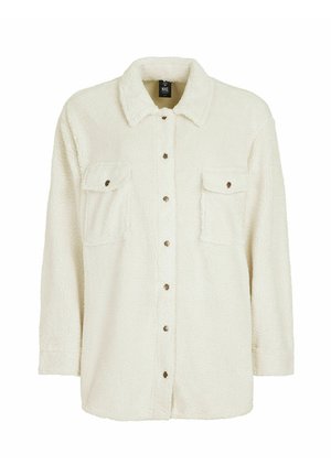 Chaqueta de camisa de forro polar color crema con collar, dos bolsillos en el pecho y cierre frontal de botones. Presenta una superficie texturizada y suave.