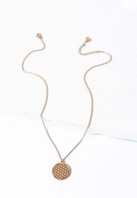 Różowozłoty naszyjnik z okrągłym wisiorkiem, na którym znajduje się geometryczny wzór wycięty laserowo. Cienki łańcuszek z małym zapięciem w kształcie serca.