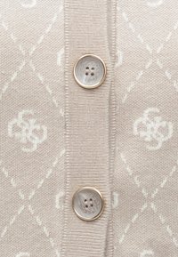 Ανοιχτό ροζ ζακέτα με υφασμάτινο πλεκτό σχέδιο και διαμάντι σχήματα. Διαθέτει δύο στρογγυλά, μαρμάρινα κουμπιά με χρυσές λεπτομέρειες.